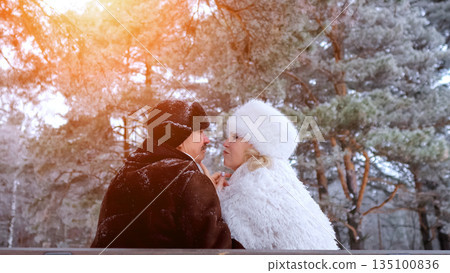 Lovers Embrace Outdoors, Couple Beneath Trees Playfully Flirt, Retired Dancers Share Tender Glance On Park Pathway, Sunlit Winter Scene With Joyful Couple Exchanging Teasing Glances 135100836
