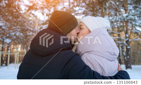 Fervent Couple Shares Warmth In Cold Scenery, Tender Couple Kisses Amidst Snow With Bright Sun Flares, Intimate Moment Captured As Lovers Embrace In Winter Snow Under Gentle Sunlight Fervent Couple Shares Warmth In Cold Scenery, Tender Couple Kisses Amidst Snow With Bright Sun Flares, Intimate Moment Captured As Lovers Embrace In Winter Snow Under Gentle Sunlight 135100843