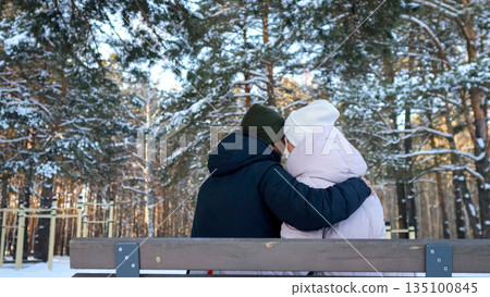 Warm Winter Moments Shared, Intimate Scene With Snowy Surroundings, Two Individuals Enjoying Cozy Winter Time Outdoors, Romantic Pair Relaxing On Bench Amidst Snow Covered Pine Trees Warm Winter Moments Shared, Intimate Scene With Snowy Surroundings, Two Individuals Enjoying Cozy Winter Time Outdoors, Romantic Pair Relaxing On Bench Amidst Snow Covered Pine Trees 135100845