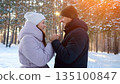 Couple Sharing Playful Sunny Winter Joy, Lesurely Couple Enjoying Sunny Winter Outdoor Scene, Two Friends Sharing Joyful Playful Moment Under Warm Winter Sun Amidst Snow And Pine Trees 135100847