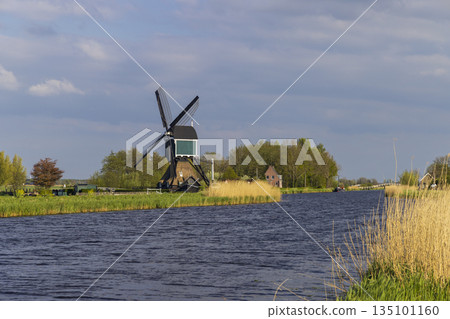 Windmill standing by canal in Molenlanden, Netherlands Windmill standing by canal in Molenlanden, Netherlands 135101160