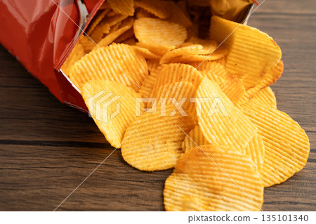 Potato chips, delicious BBQ seasoning spicy for crips, thin slice deep fried snack fast food in open bag. 135101340