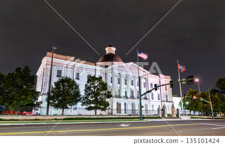 Old Capitol Museum stands in Jackson, Mississippi, USA. Historic Greek Revival architecture features the dome and stone columns illuminated by lights under a dark night sky 135101424