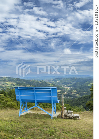 Giant blue bench overlooking Niella Belbo valley panorama Giant blue bench overlooking Niella Belbo valley panorama 135101617