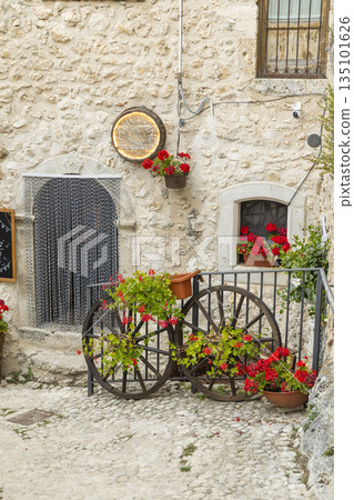Calascio street decorated with flower pots and old wagon wheels 135101626