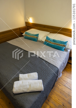 Cozy hotel bedroom with fresh towels on bed Cozy hotel bedroom with fresh towels on bed 135101701