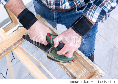 Carpenter at work, restoring an old wooden window. Carpentry. 135102113