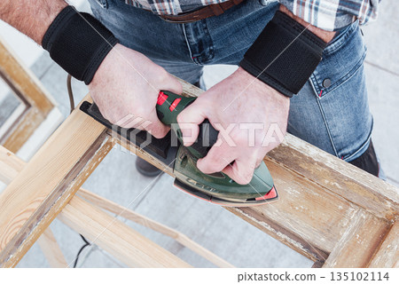 Carpenter at work, restoring an old wooden window. Carpentry. 135102114