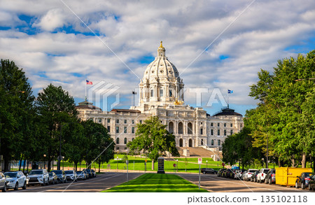 Minnesota State Capitol is located in Saint Paul, USA. Historic Beaux-Arts architecture features the white marble dome and golden Quadriga statue under a blue sky with clouds 135102118