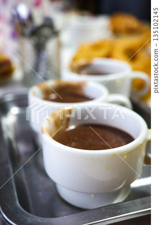 Hot chocolate in cups for traditional Spanish churros Hot chocolate in cups for traditional Spanish churros 135102145