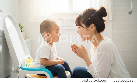 微笑的母親和蹣跚學步的孩子正在觀看如廁訓練 微笑的母親和蹣跚學步的孩子正在觀看如廁訓練 135102152