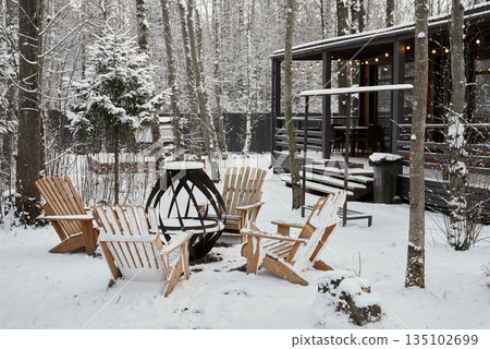 Serene snowy circle with chairs and stove for gatherings 135102699