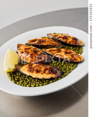 close vertical shot of baked mussels on peas, editorial 135102833