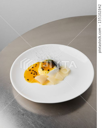 Artfully styled passionfruit custard with garnishes and sheen 135102842
