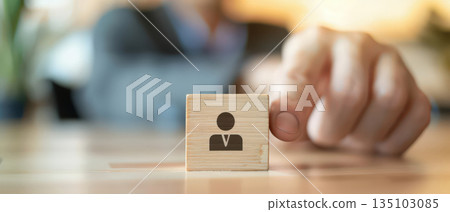 Hand selecting wooden block with person icon for recruitment concept Hand selecting wooden block with person icon for recruitment concept 135103085