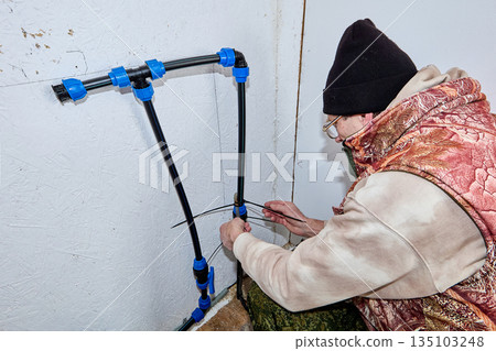 Installation of heating cable on incoming pipe in winterized rural house. Installation of heating cable on incoming pipe in winterized rural house. 135103248