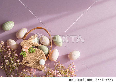 Pastel Easter Bunny Basket with Eggs and Flowers on Lavender Background 135103365