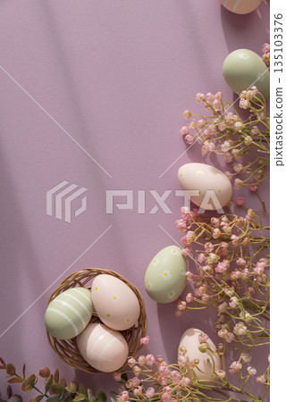Pastel Easter Eggs in Wicker Basket with Flowers on Pink Background 135103376