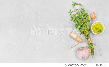 Fresh thyme herbs with garlic, olive oil and sea salt on light stone background, top view flat lay with copy space for healthy cooking and culinary branding concept Fresh thyme herbs with garlic, olive oil and sea salt on light stone background, top view flat lay with copy space for healthy cooking and culinary branding concept 135103432