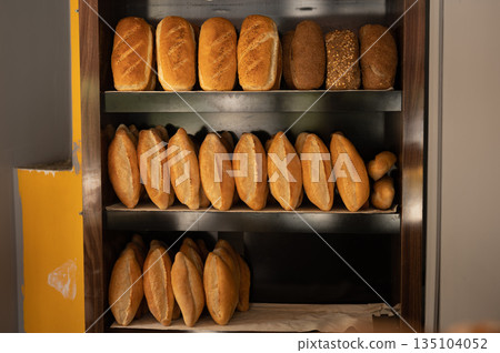 Freshly Baked Bread Loaves on Wooden Shelves 135104052