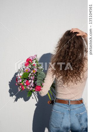 Woman Holding Vibrant Bouquet Against White Wall Woman Holding Vibrant Bouquet Against White Wall 135104561