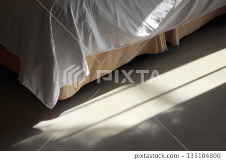 Bed casts a clear shadow on the floor, highlighting bedtime tranquility during morning light Bed casts a clear shadow on the floor, highlighting bedtime tranquility during morning light 135104800