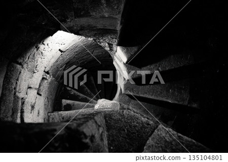 Spiraling stone staircase leading deep into darkness and mystery below Spiraling stone staircase leading deep into darkness and mystery below 135104801