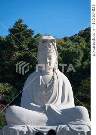 Large white statue of Guanyin meditating in Japan against blue sky Large white statue of Guanyin meditating in Japan against blue sky 135104829