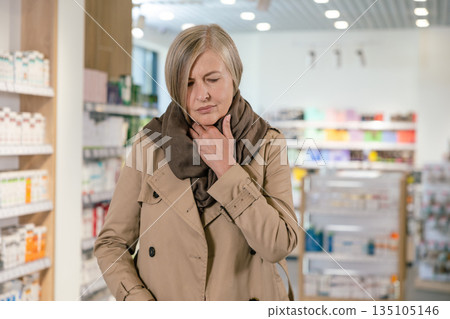 Mature caucasian woman feeling sick and shivering in the drug store 135105146