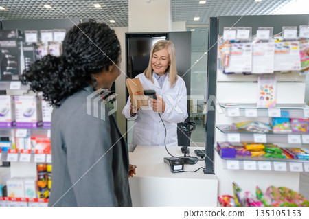 Female customer talking to a pharmacist at the cashier desk Female customer talking to a pharmacist at the cashier desk 135105153
