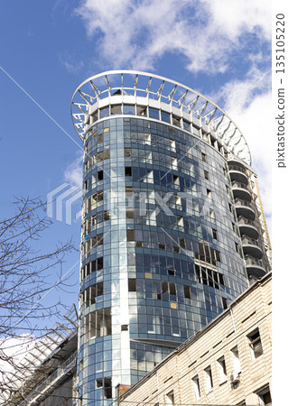 Urban building with shattered windows caused by a rocket attack showing the impact of war and civilian infrastructure damage 135105220