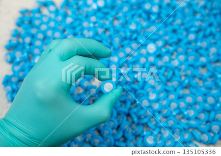 Female hand holding laboratory syringe filters, concept of sterile sample preparation. Female hand holding laboratory syringe filters, concept of sterile sample preparation. 135105336