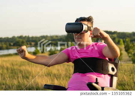 Man with disability enjoying VR gaming outdoors, combining technology, freedom, and nature. Man with disability enjoying VR gaming outdoors, combining technology, freedom, and nature. 135105362