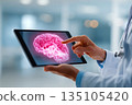 A healthcare professional presents a brain X-ray on a tablet to a patient in a clean, modern medical setting. The consultation aims for better understanding and care. 135105420