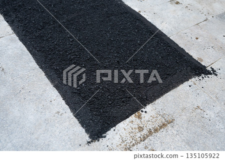 Fresh asphalt covering a section of a concrete sidewalk Fresh asphalt covering a section of a concrete sidewalk 135105922