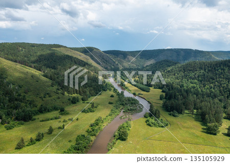 River flowing through forested valley under cloudy sky River flowing through forested valley under cloudy sky 135105929