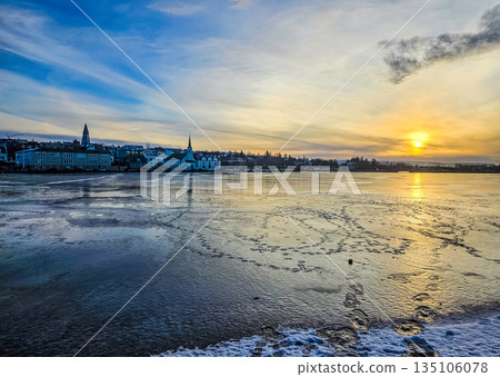 Winter Sunrise over Frozen Lake Tjornin in Reykjavik 135106078