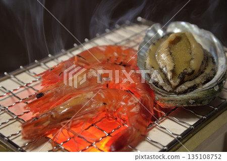 在煙燻炭火烤架上烤鮑魚和蝦 在煙燻炭火烤架上烤鮑魚和蝦 135108752