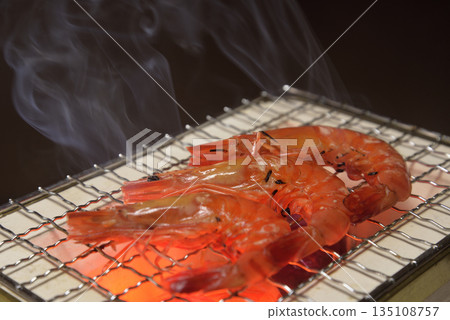 Grilling shrimp on a smoky charcoal grill Grilling shrimp on a smoky charcoal grill 135108757