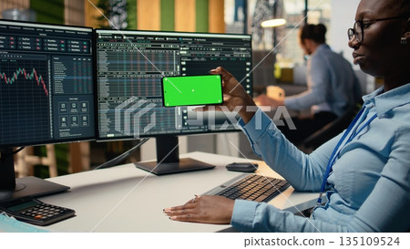 Prop firm intern in office learns new trading strategies from video lesson on green screen mobile phone. Brokerage company trainee using chroma key smartphone to watch educational content Prop firm intern in office learns new trading strategies from video lesson on green screen mobile phone. Brokerage company trainee using chroma key smartphone to watch educational content 135109524
