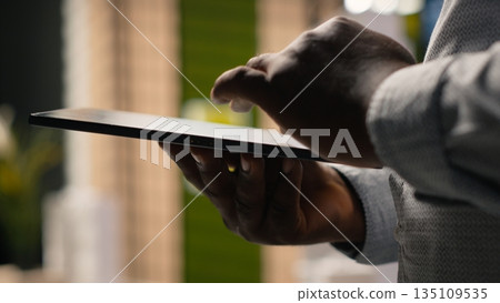 African american developer evaluating 3D models blueprints and digital software as part of strategic housing project in urban development area. City planning business project on tablet. 135109535