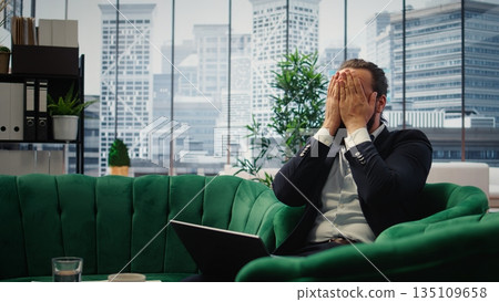 Overburdened director dealing with workload and financial instability, struggling to keep his business economy on the line. Unsuccessful anxious man feeling hopeless due to problems. Camera A. 135109658