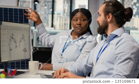 RD department coworkers optimize sustainable solar panel fabrication, working on green energy innovation. Teamworking alternative energy experts innovate solar manufacturing, camera B 135109671