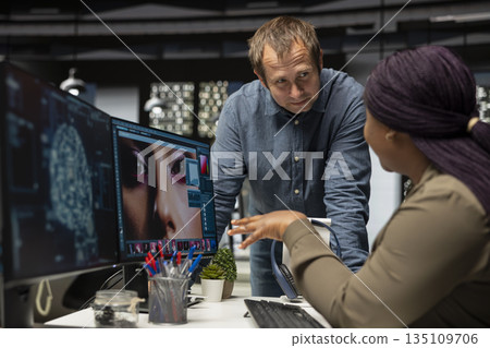 Diverse photo editing team use neural networks for retouching materials, machine learning and editing new photo content online. Professional designers using digital software and AI. 135109706