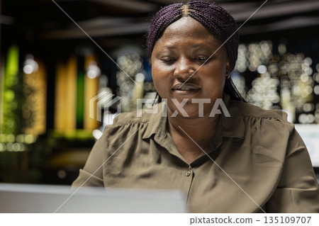 Manager researching numbers and finance figures in a dark office after hours, documenting updates and organizing the agenda for upcoming business presentation. Setting targets at night. 135109707