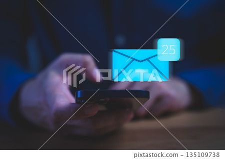 Person checking smartphone with a digital envelope icon notification, representing new email messages, communication technology, inbox management, mobile mail app alerts, and online correspondence. Person checking smartphone with a digital envelope icon notification, representing new email messages, communication technology, inbox management, mobile mail app alerts, and online correspondence. 135109738