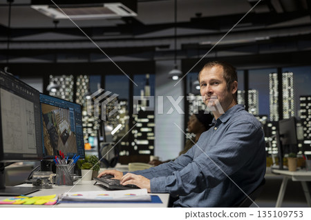 Professional worker in creative office uses CAD software and blueprints plan, designing a house interior with a user interface for virtual home customization. Detailed architectural layout. Professional worker in creative office uses CAD software and blueprints plan, designing a house interior with a user interface for virtual home customization. Detailed architectural layout. 135109753
