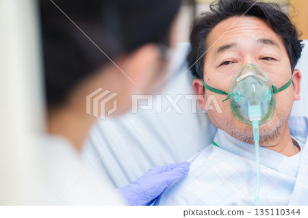 A male hospitalized patient talking while wearing a ventilator A male hospitalized patient talking while wearing a ventilator 135110344