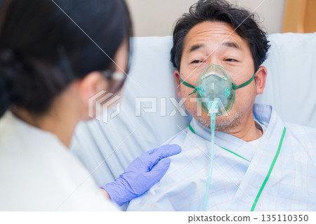 一名男性住院病人戴著呼吸器說話 一名男性住院病人戴著呼吸器說話 135110350