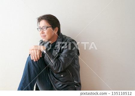 一位五十多歲、戴著眼鏡、穿著皮夾克的男子 一位五十多歲、戴著眼鏡、穿著皮夾克的男子 135110512